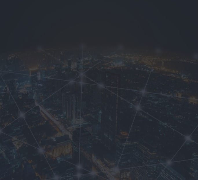 Nighttime aerial view of a city with illuminated streets and buildings, overlaid with a network of glowing Internet connections.